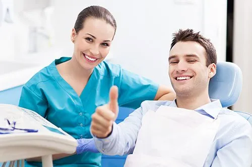 smiling man at dental office giving thumbs up